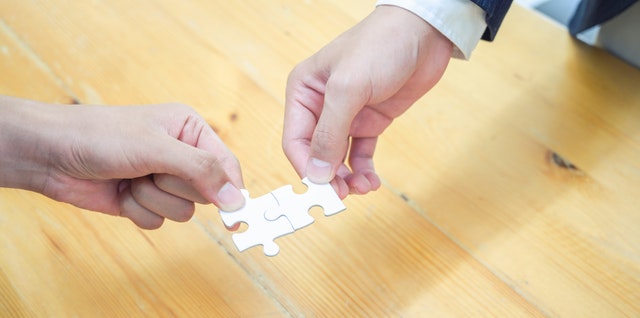 person holding white jigsaw puzzle piece 3740403
